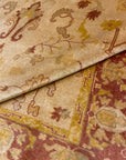 Close-up of a Vintage Angora Oushak rug featuring intricate floral and scroll designs in muted red, beige, and green tones.