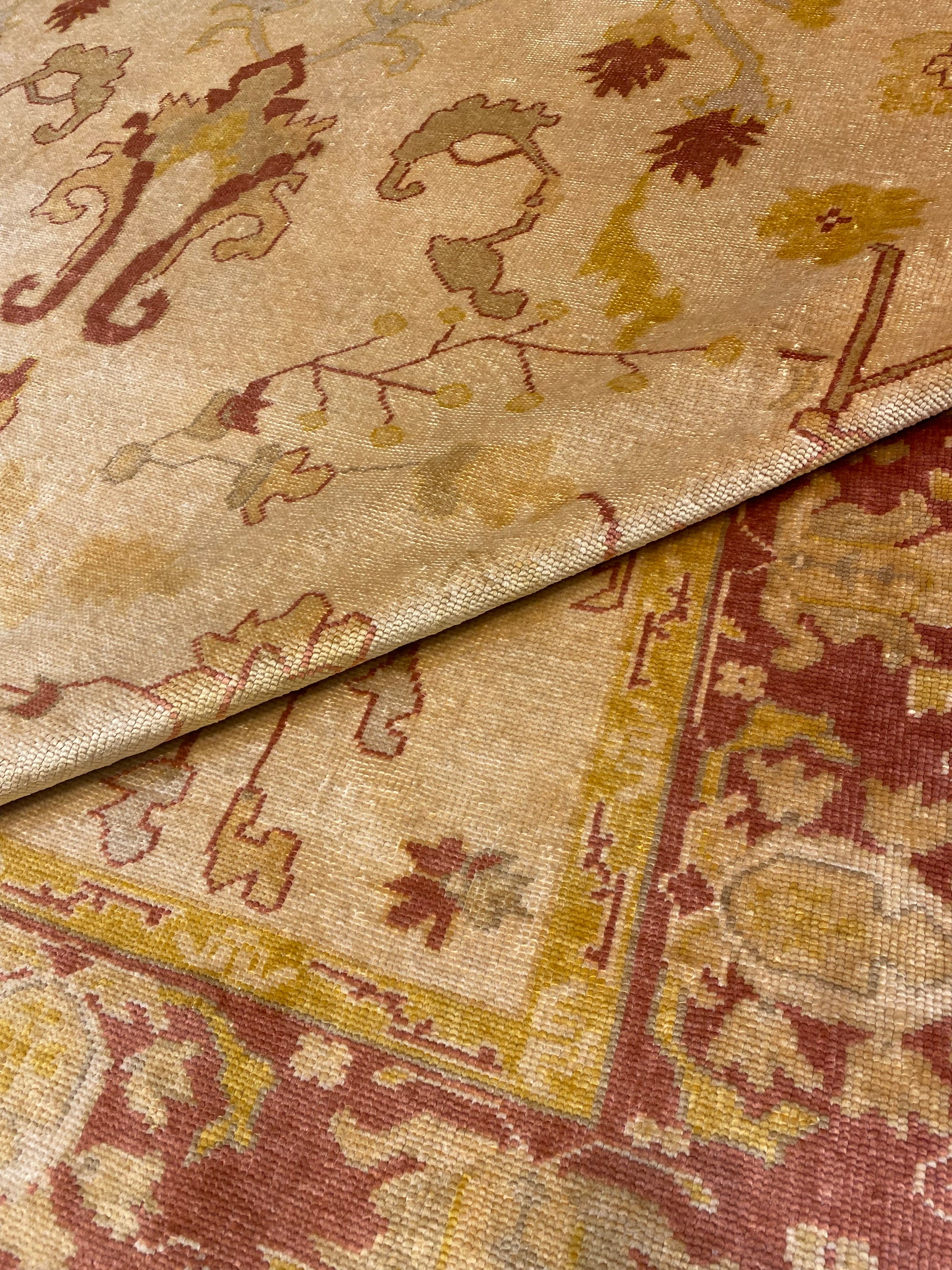 Close-up of a Vintage Angora Oushak rug featuring intricate floral and scroll designs in muted red, beige, and green tones.