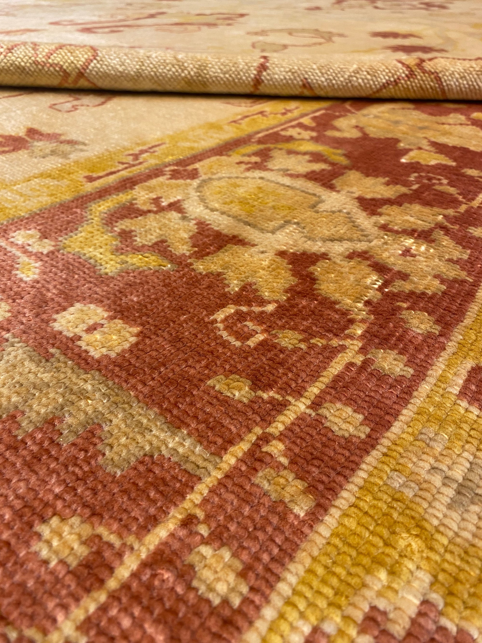 Close-up of a Vintage Angora Oushak rug, showcasing intricate patterns with earthy tones of red, yellow, and beige.